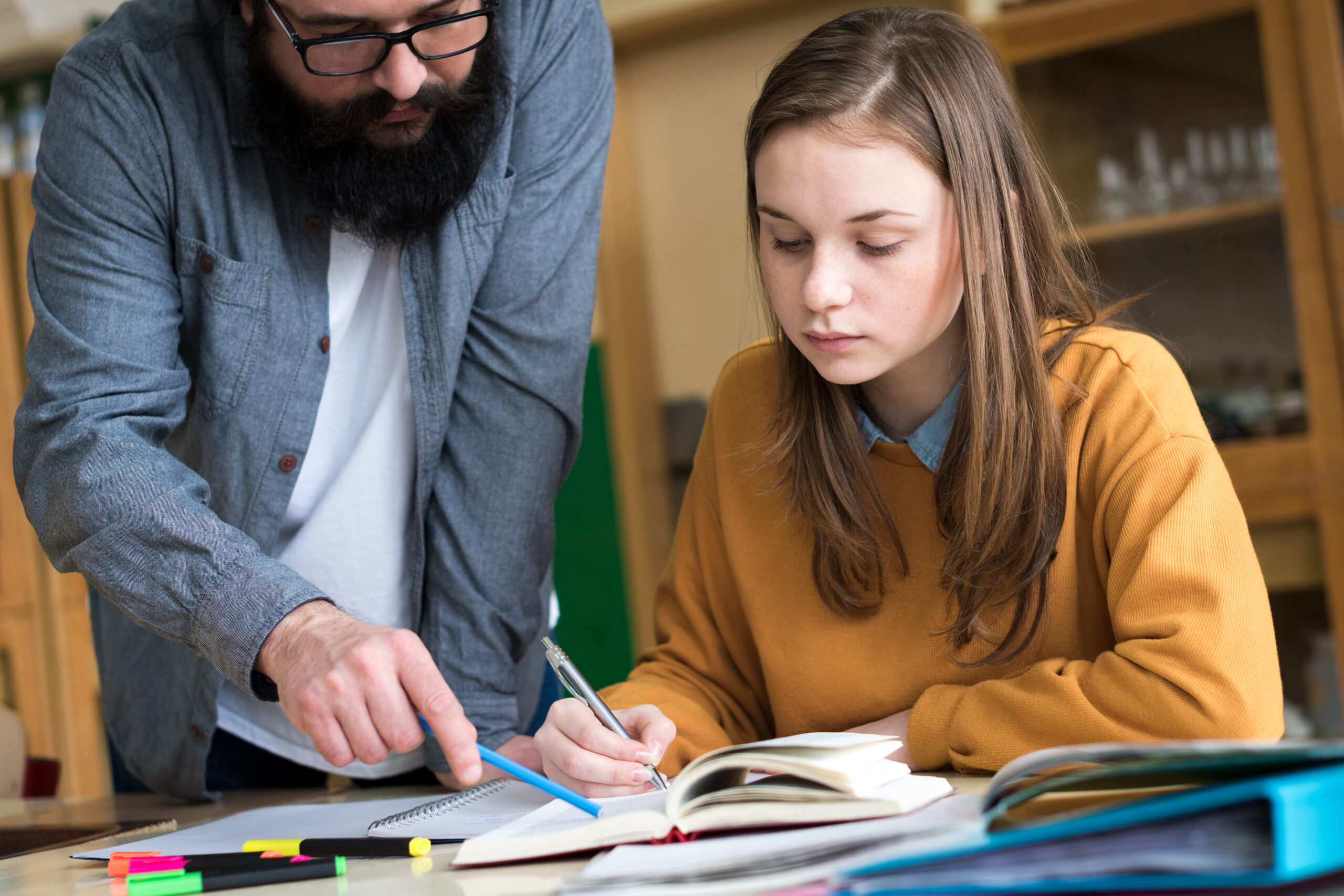 Adult helping teenager with homework